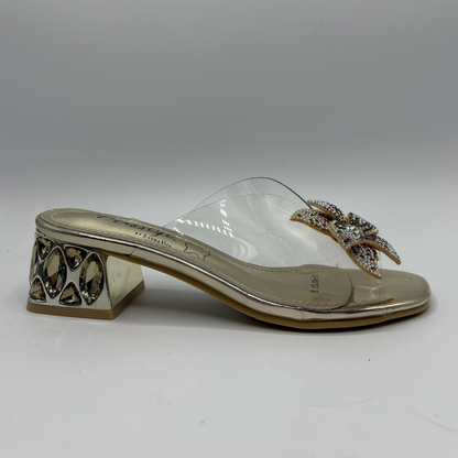 Clear sandal with decorative strap and low heel on a gray background