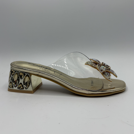 Clear sandal with decorative strap and low heel on a gray background
