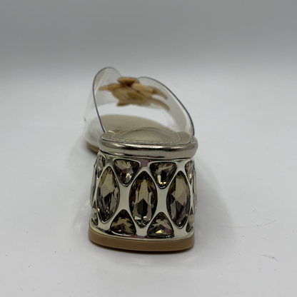 Clear sandal with decorative strap and low heel on a gray background