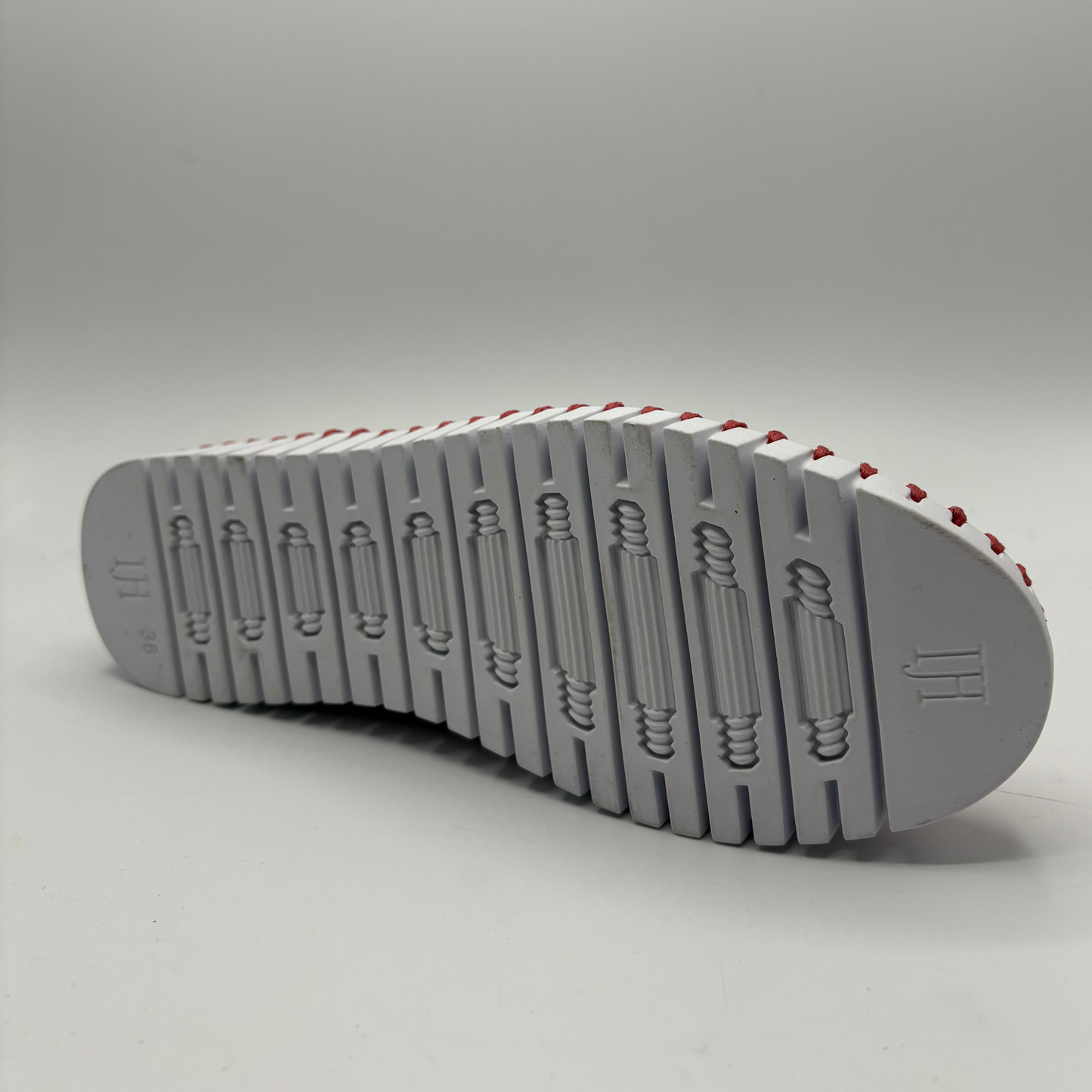 Gray shoe sole with red accents on a gray background