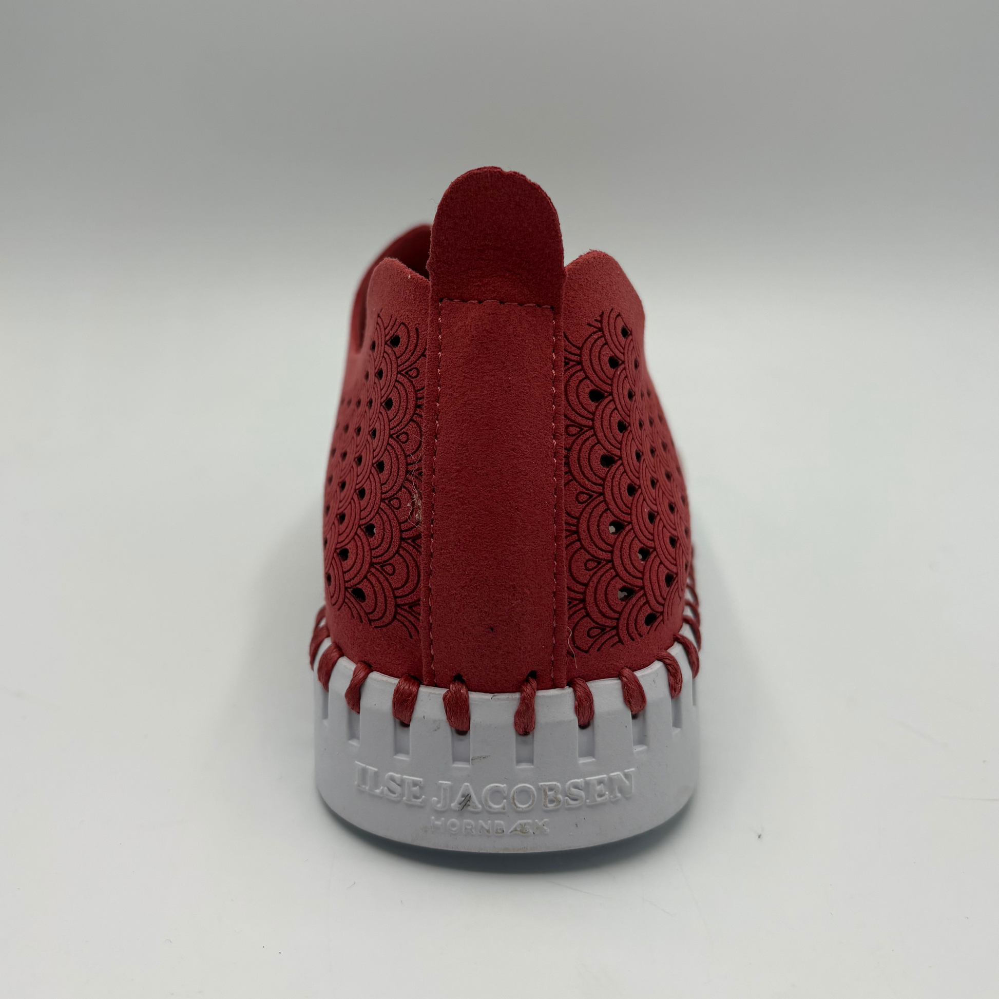 Red shoe with white sole on a gray background