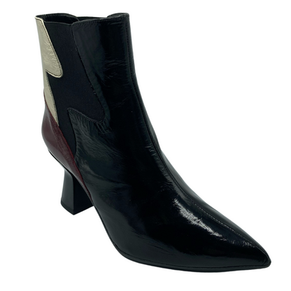 45 degree angled view of leather ankle boot with pointed toe, flared heel and coloured leather accents on shaft