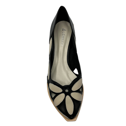 Top view of black and white pump with pointed toe and mesh and cut out details