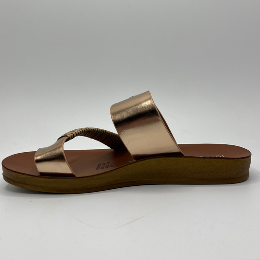 Left facing view of a rose gold strapped sandal with a gold buckle and brown insole