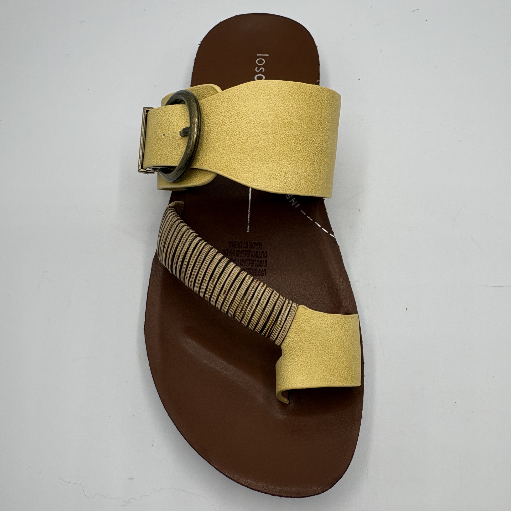 Brown sandal with yellow straps on a white background