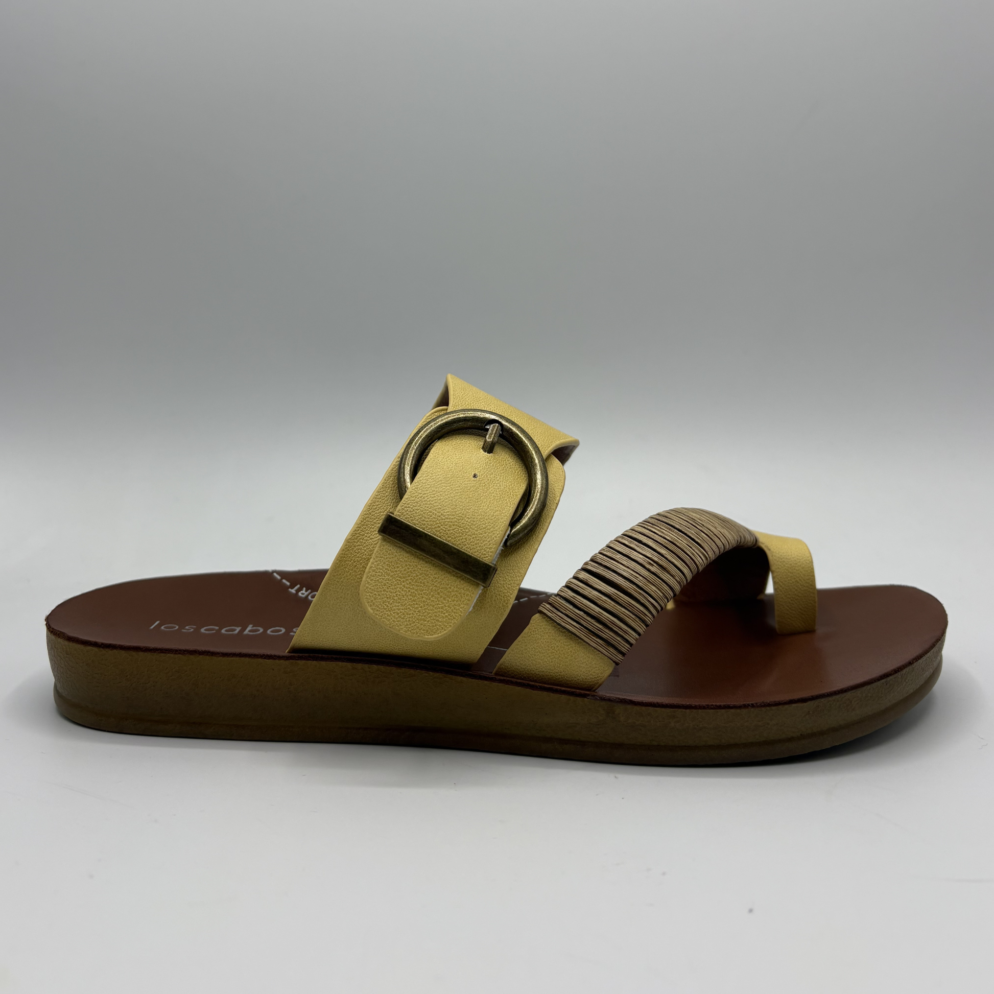 Yellow sandal with a brown sole on a gray background