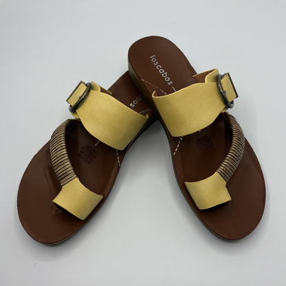 Brown sandals with yellow straps on a white background