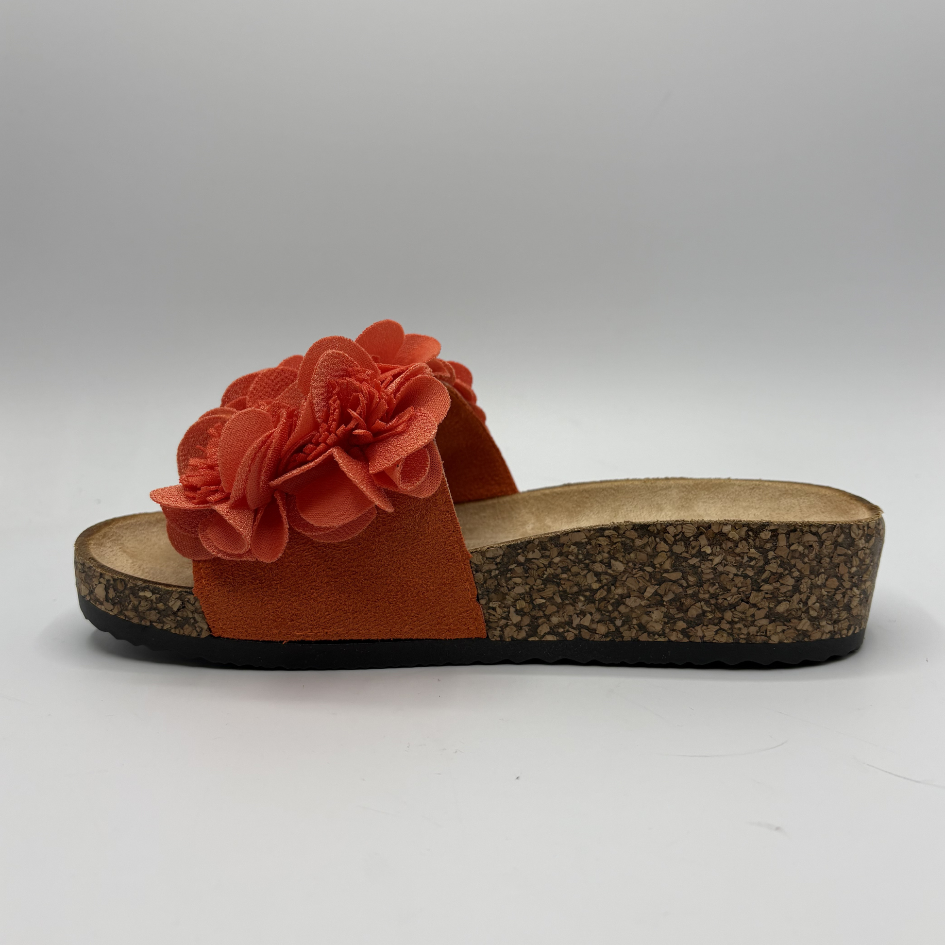 Orange sandal with a flower detail on a white background