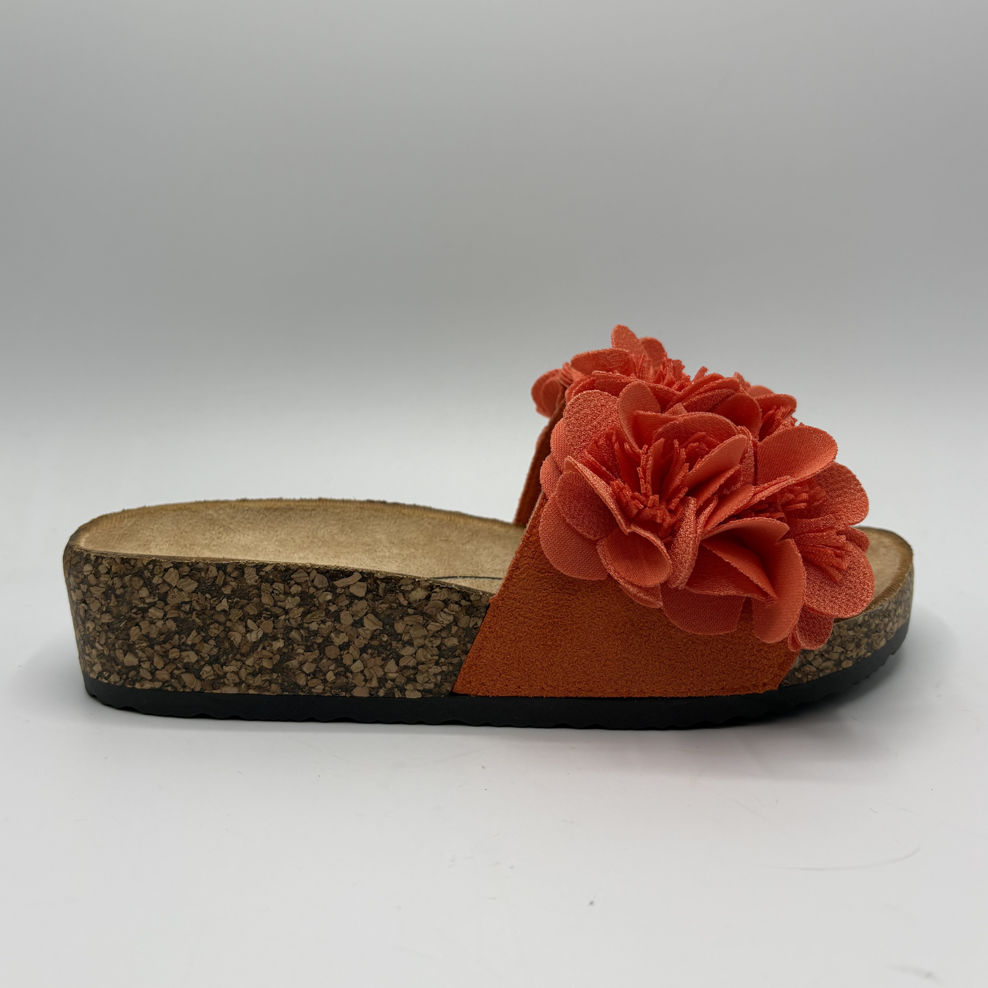 Orange sandal with a flower detail on a white background
