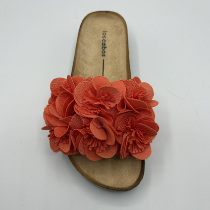 Orange sandal with a flower detail on a white background