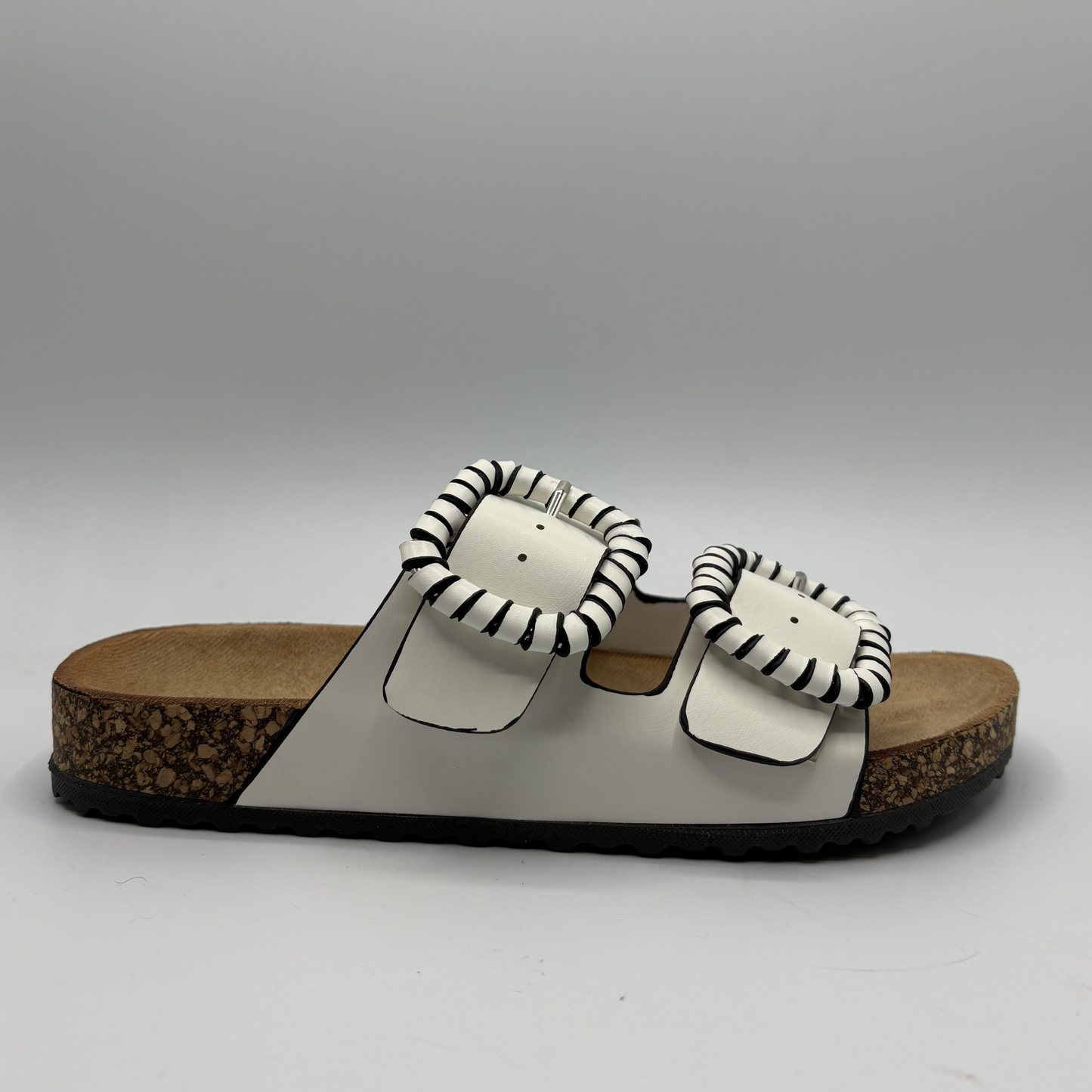 White sandals with striped pattern straps on a gray background
