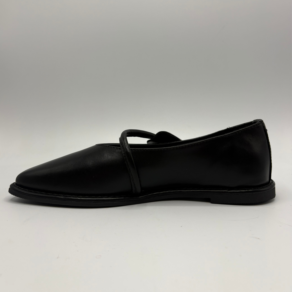 Left facing view of a black leather ballet flat shoe with silver accents