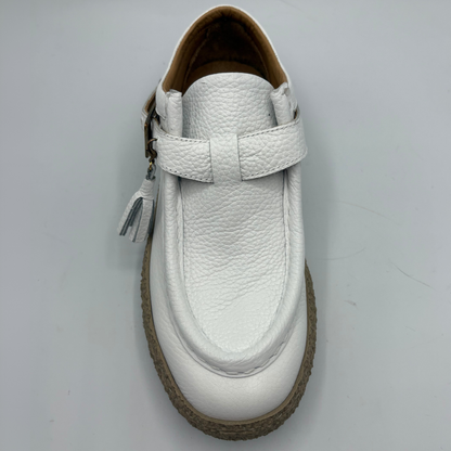 Top view of a white leather shoe with a rubber outsole and a buckle closure