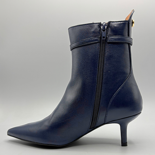 A navy blue leather ankle boot with a pointed toe, a slim kitten heel, and a side zipper, shown from a three-quarters angle against a neutral gray background.