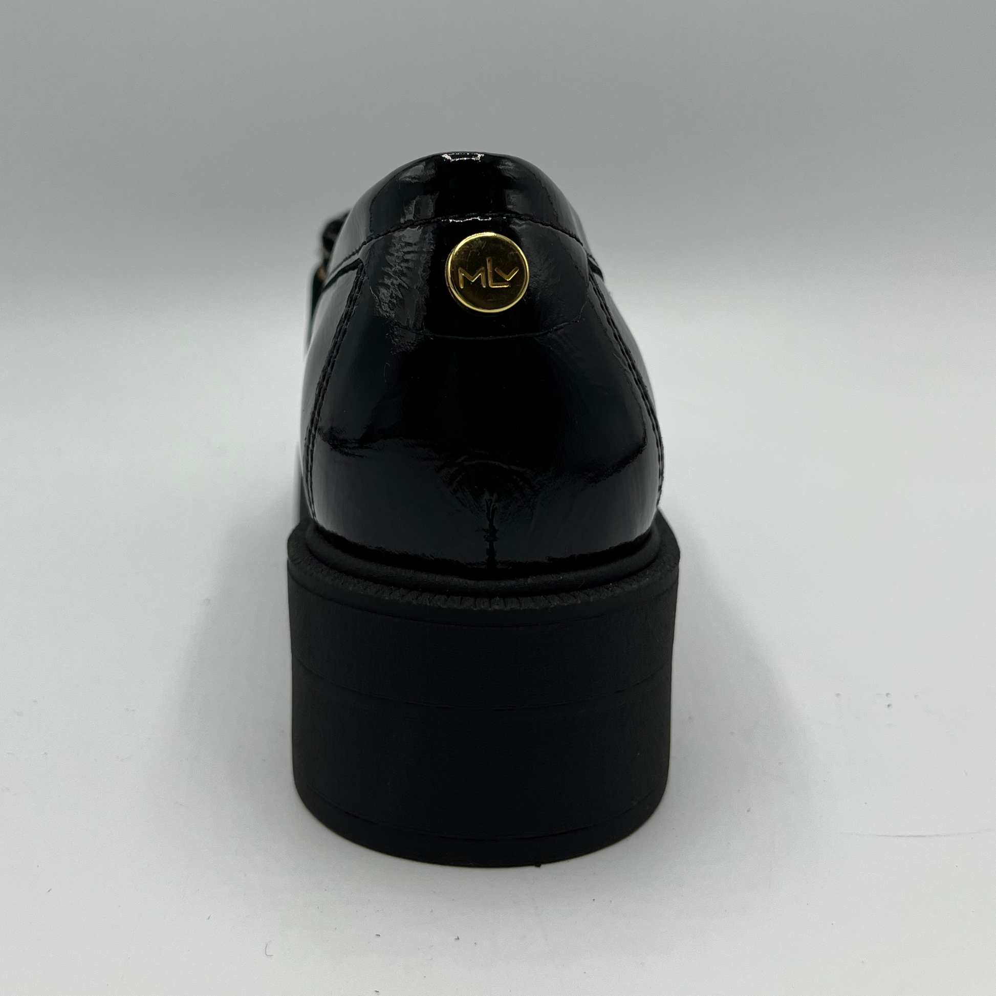 Black patent leather shoe with a gold logo on a white background