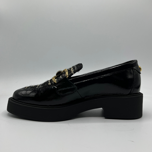 Black loafers with decorative elements on a gray background