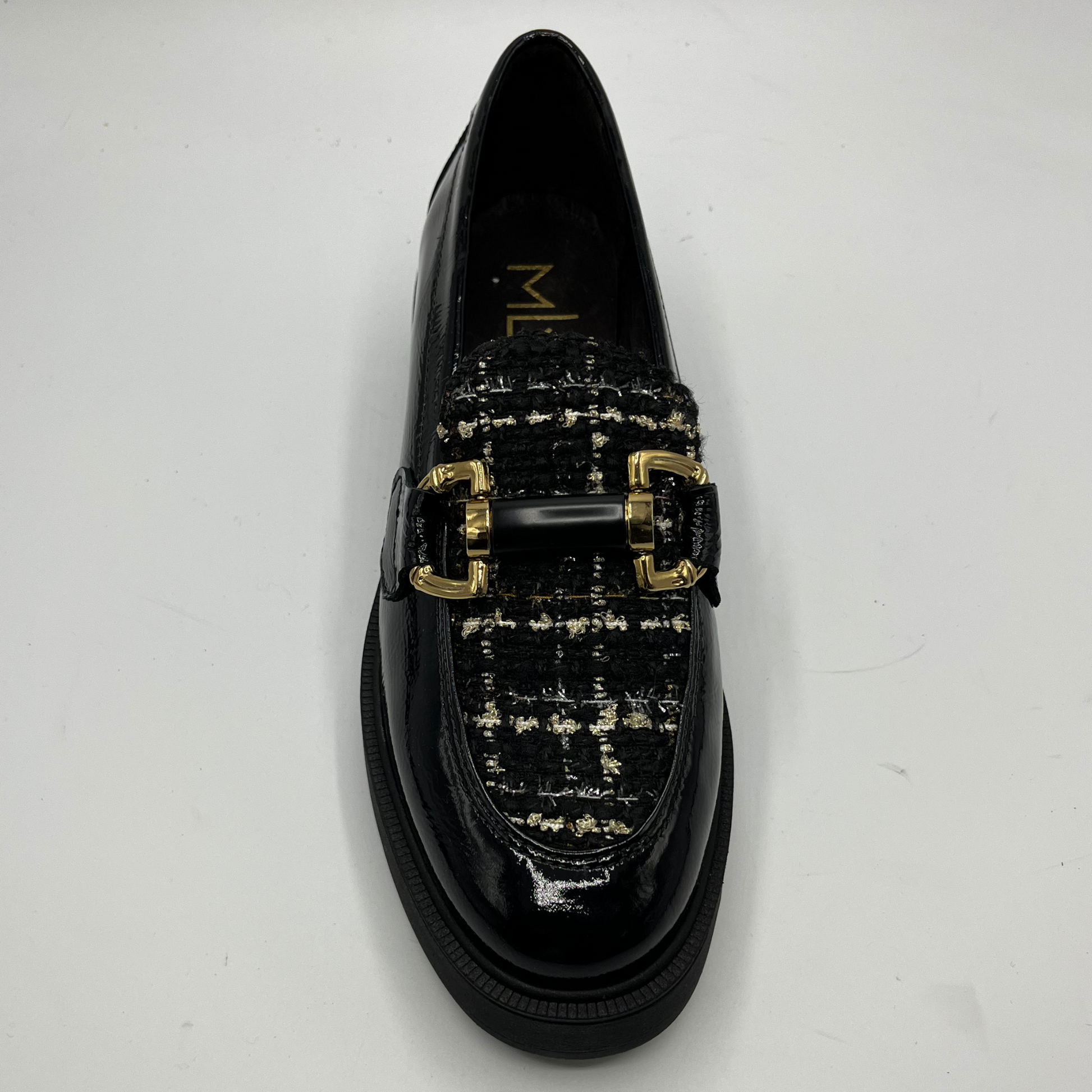 Black loafers with gold buckles on a white background