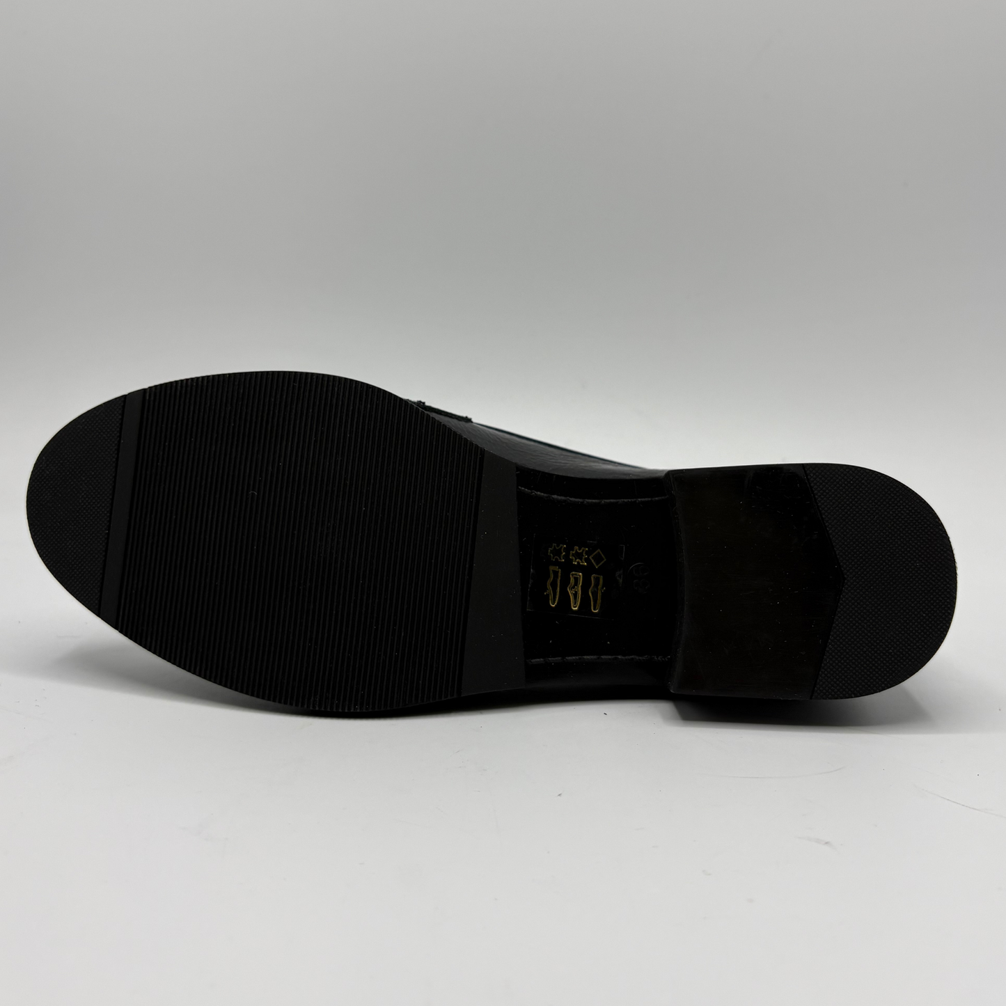 Bottom view of a black leather loafer with an animal print accent on the toe box and chain detail.