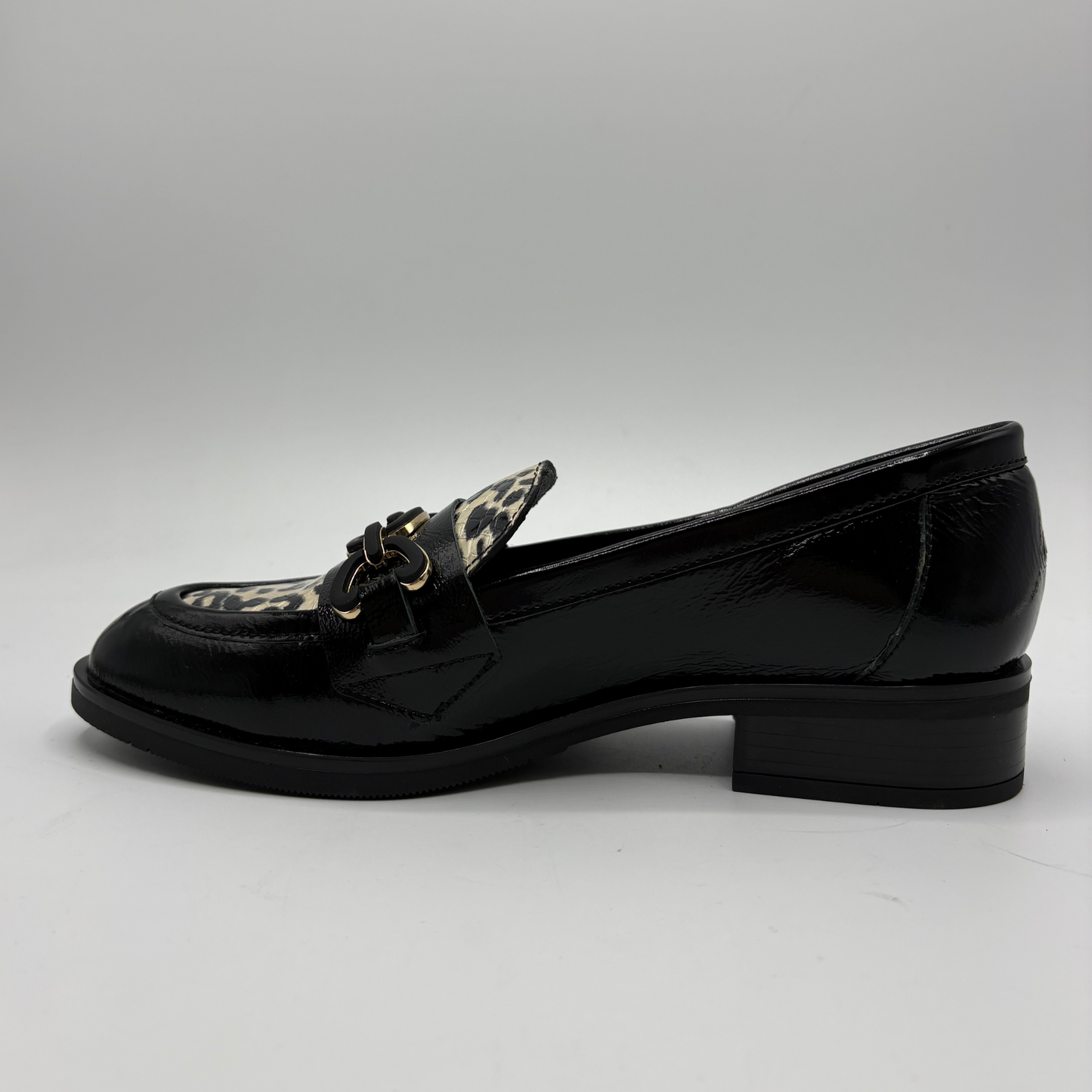 Left view of a black leather loafer with an animal print accent on the toe box and chain detail.