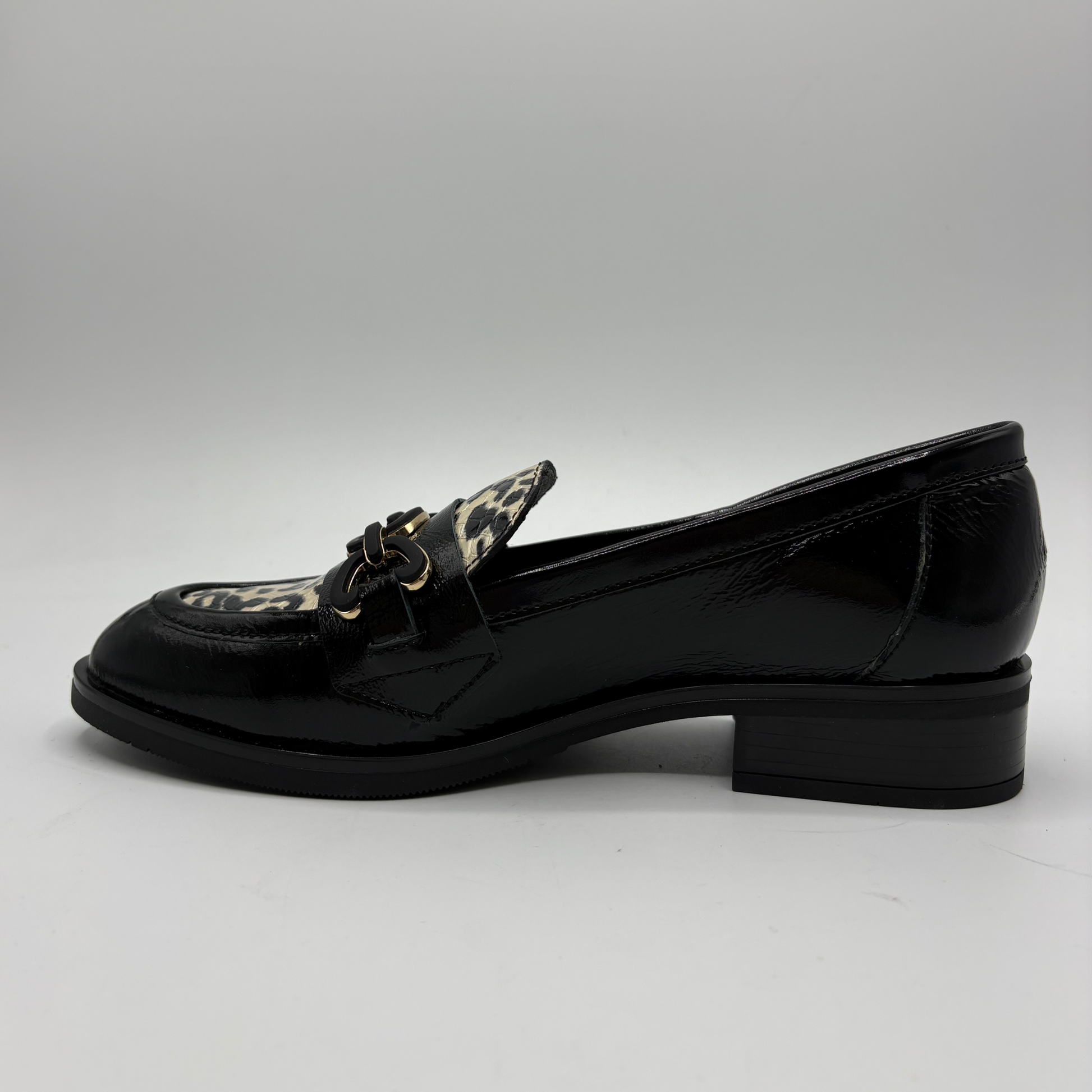 Left view of a black leather loafer with an animal print accent on the toe box and chain detail.