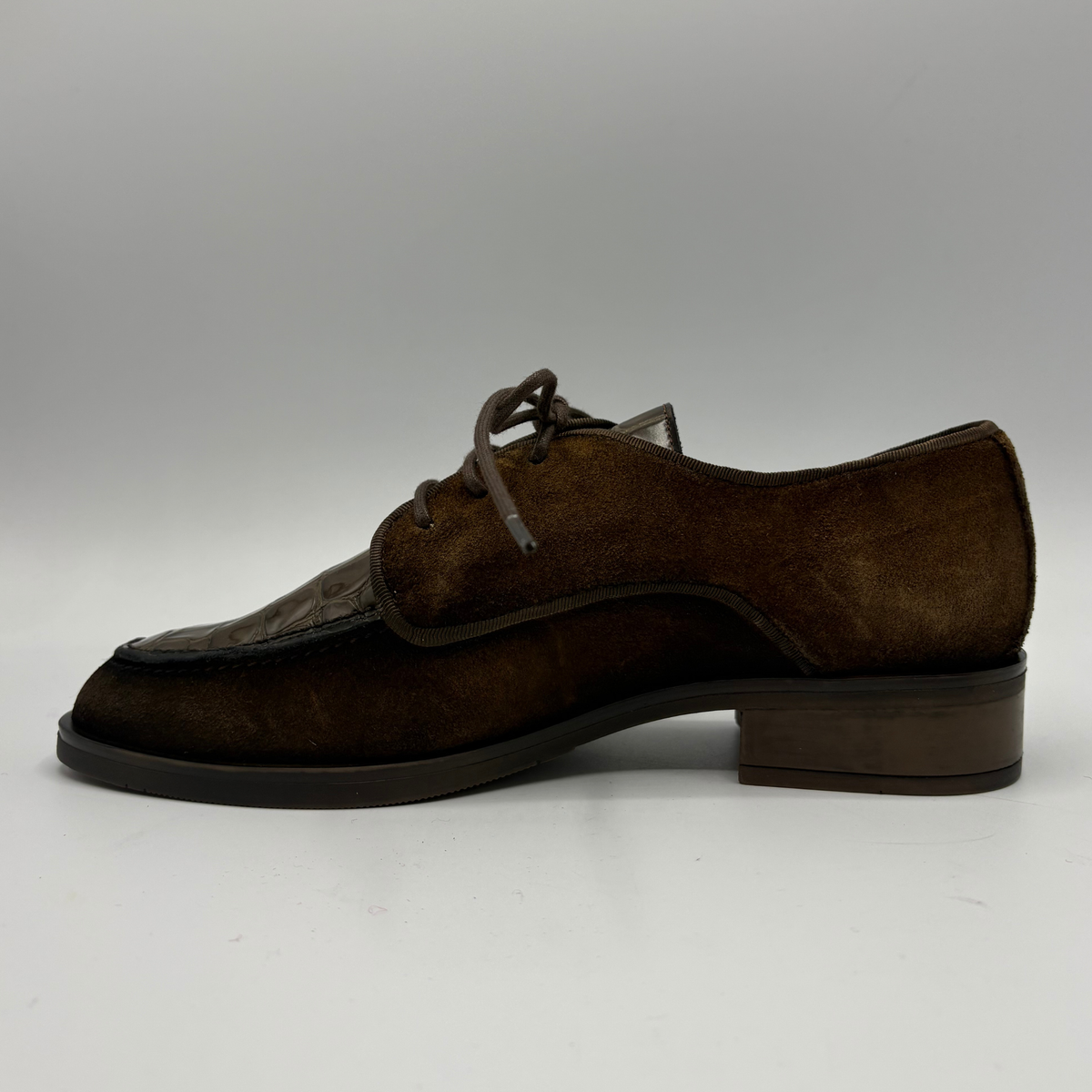 Left facing view of a brown oxford shoe with a short stacked heel and matching laces