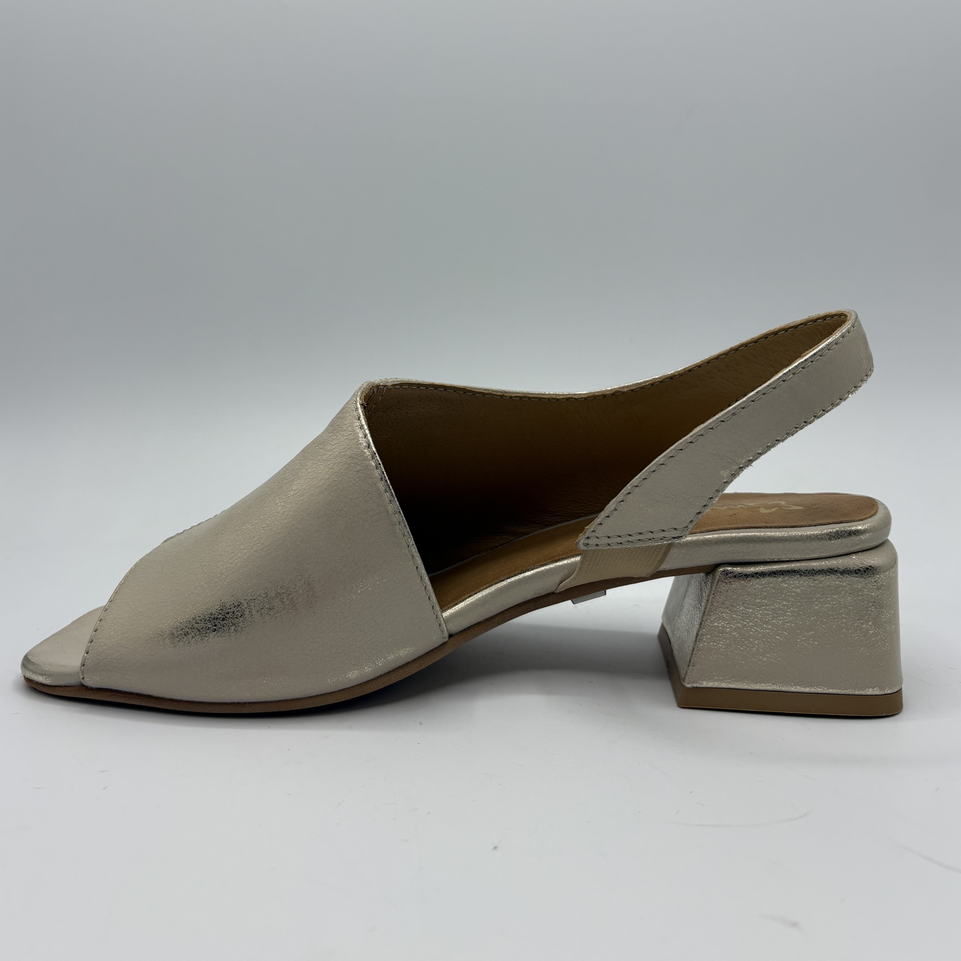 Shiny beige sandal with block heel on a gray background