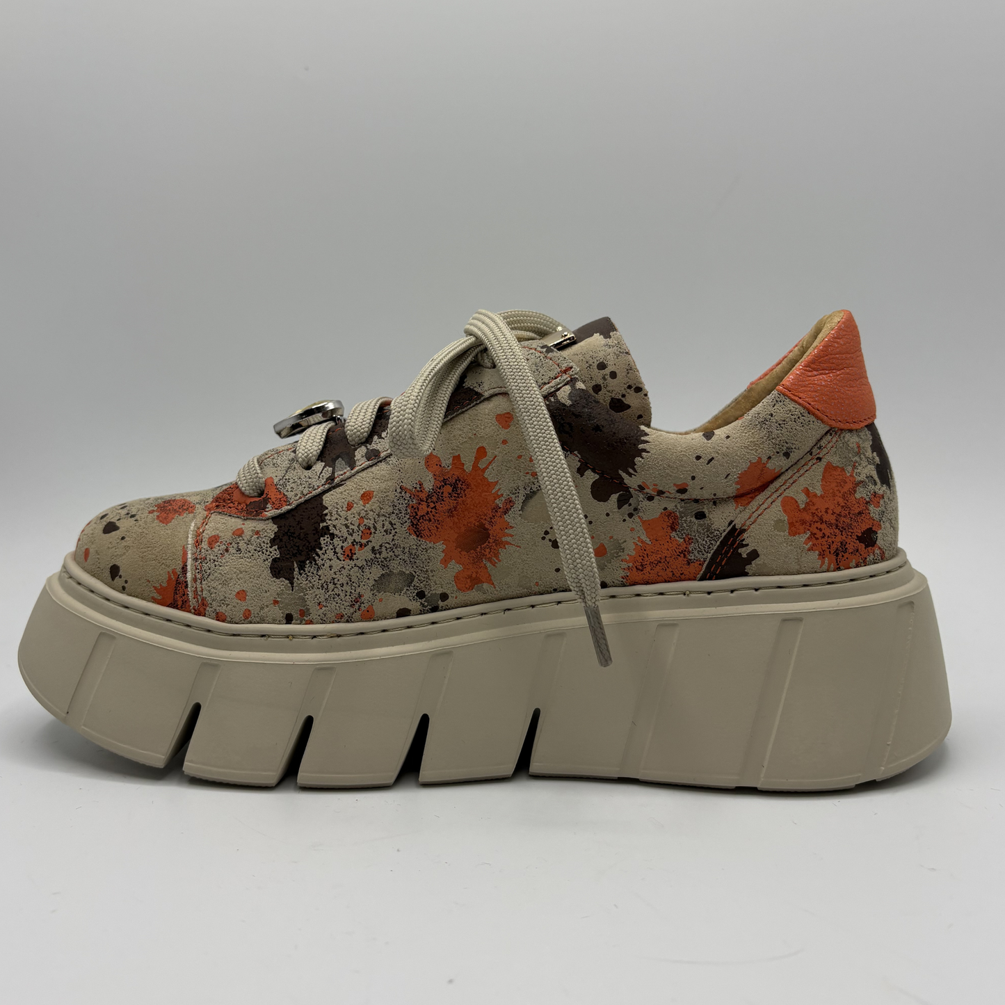 Splatter patterned sneaker with a thick sole on a gray background