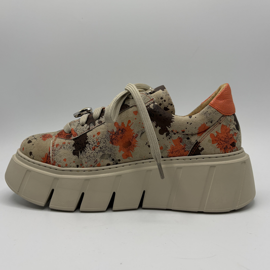 Splatter patterned sneaker with a thick sole on a gray background