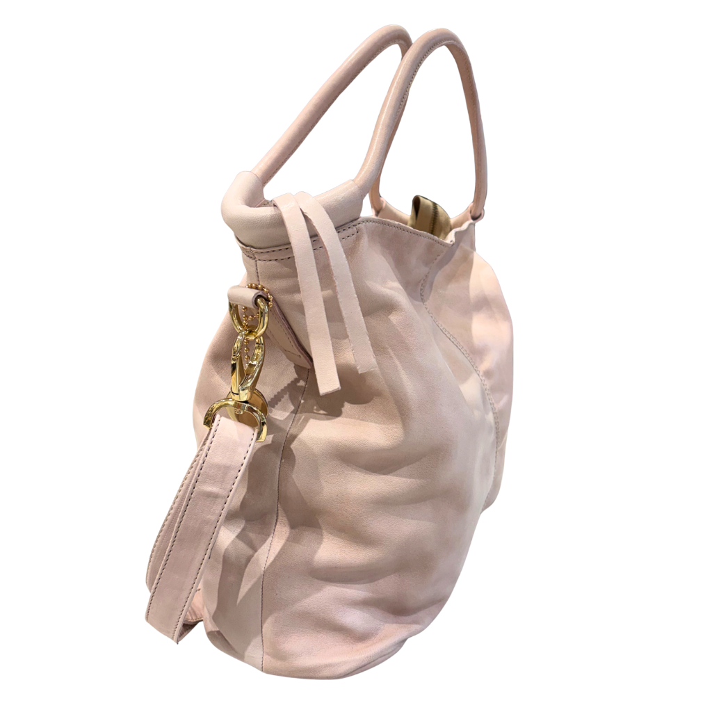 Soft pink handbag with gold accents on a white background