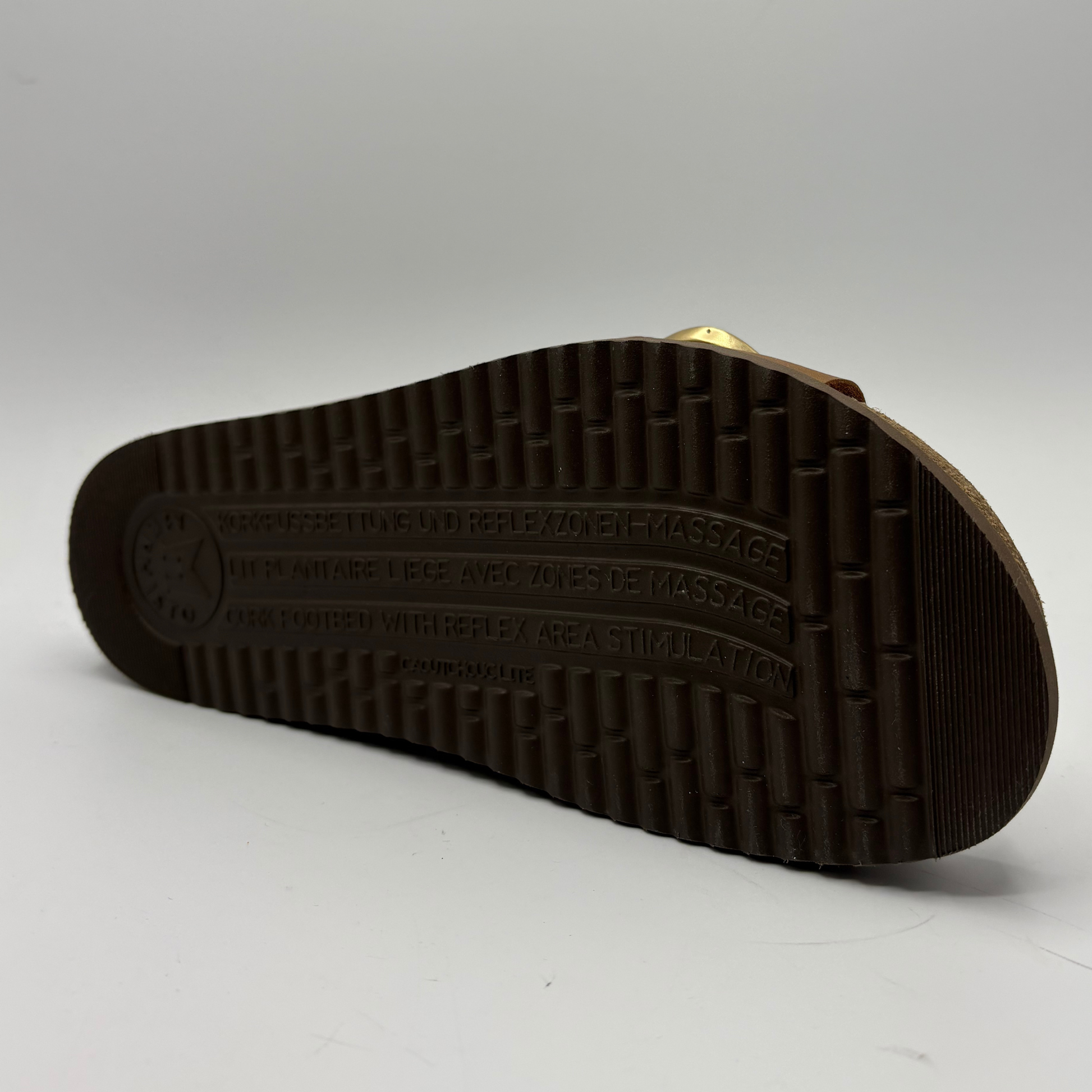 Close-up of a sandal sole with brand logo on a gray background