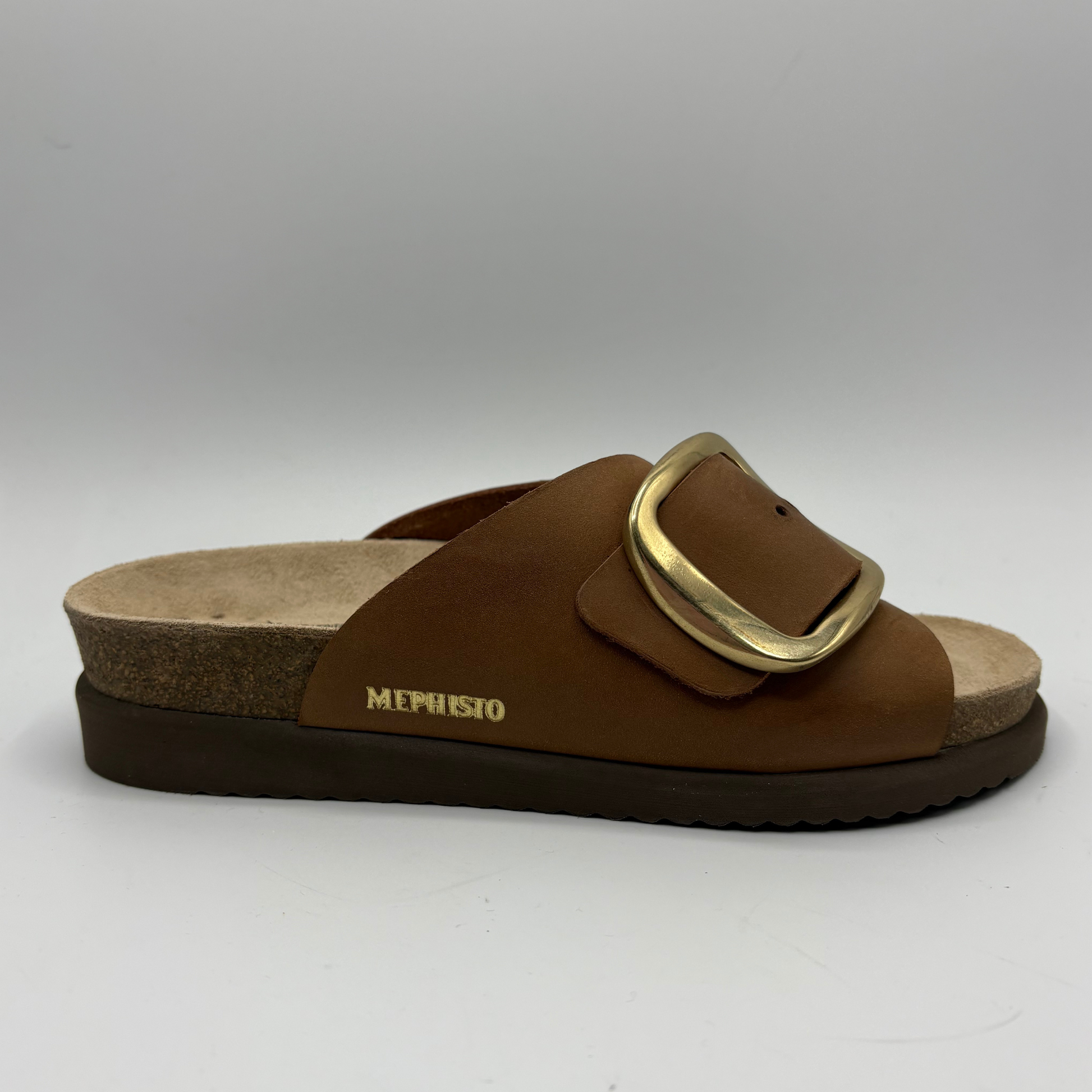 Brown sandal with gold buckle on a gray background