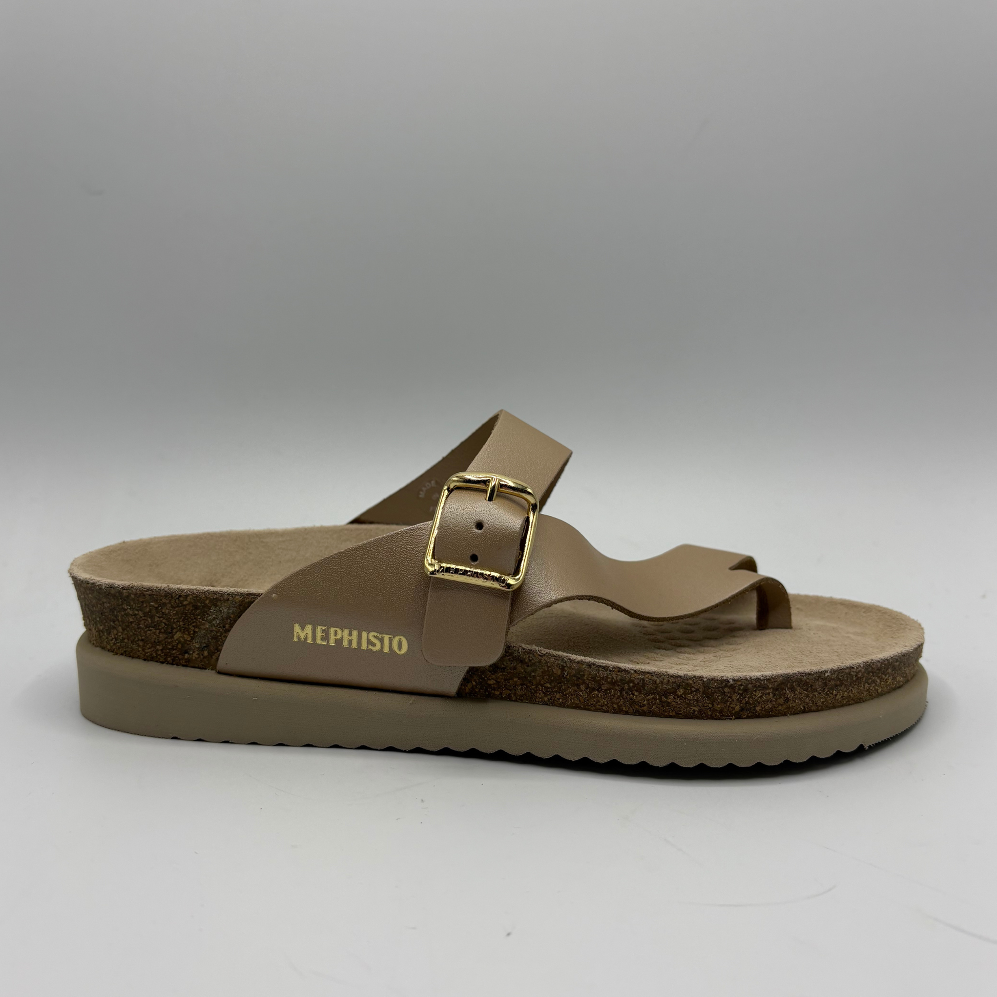Brown sandal with a gold buckle on a gray background