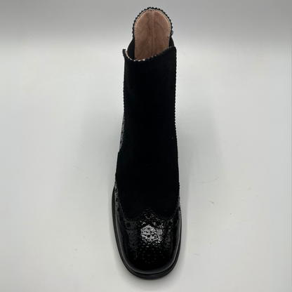 Black ankle boot with patterned sole on a white background