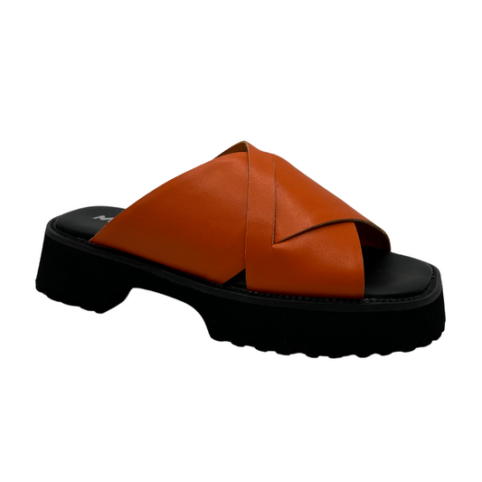 45 degree angled view of orange leather sandal with thick black sole, cross over straps and open toe