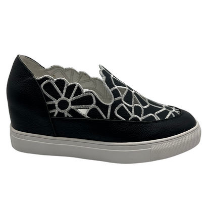 Right facing view of leather wedge sneaker with hidden wedge, cut out and embroidered upper and white rubber outsole.