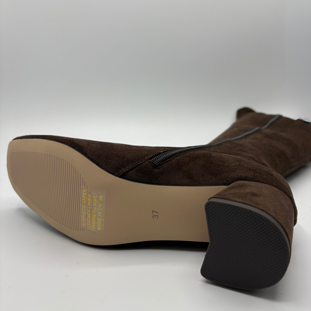 Bottom view of a brown suede tall boot with a wrapped heel
