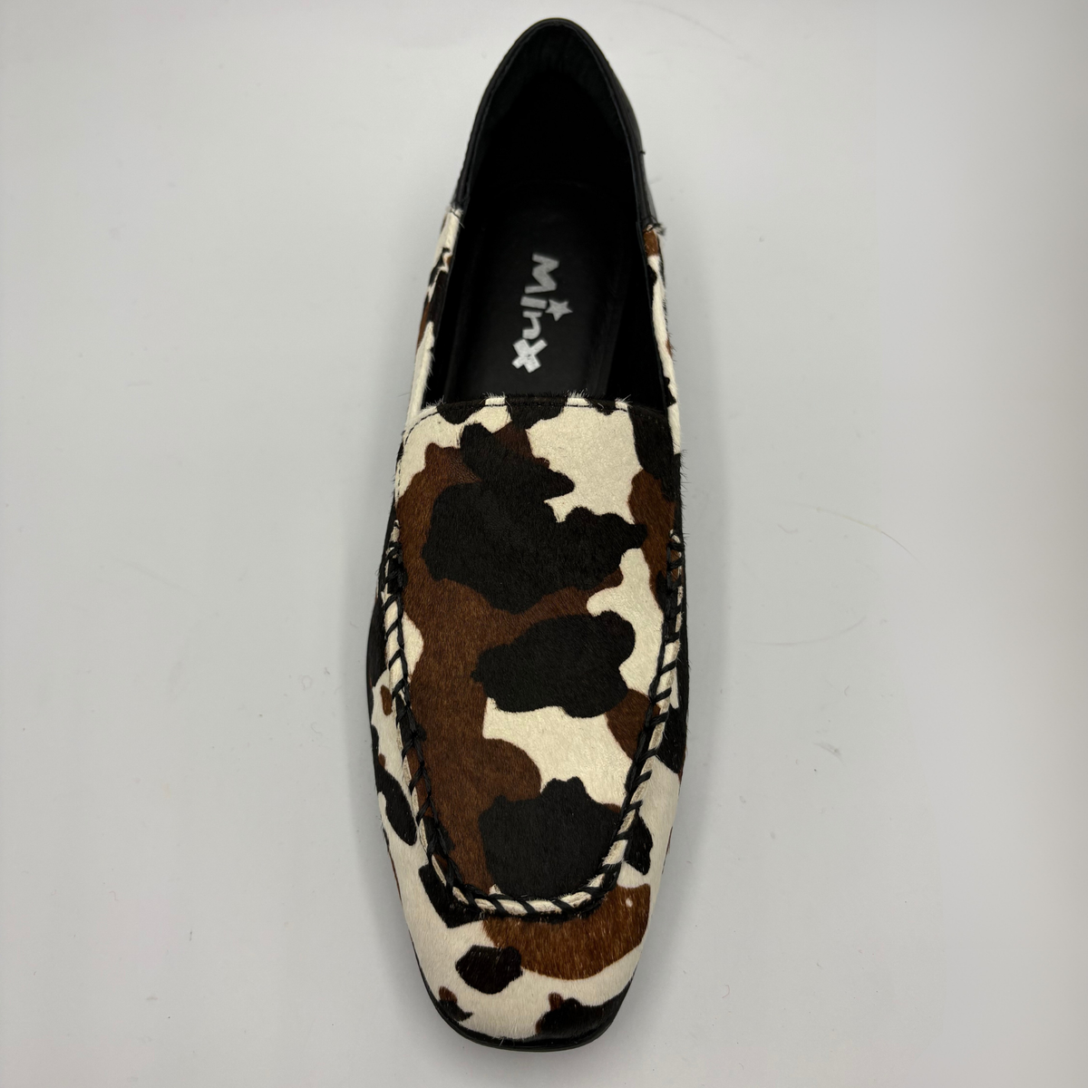 Top view of a cow print suede loafer with a low heel