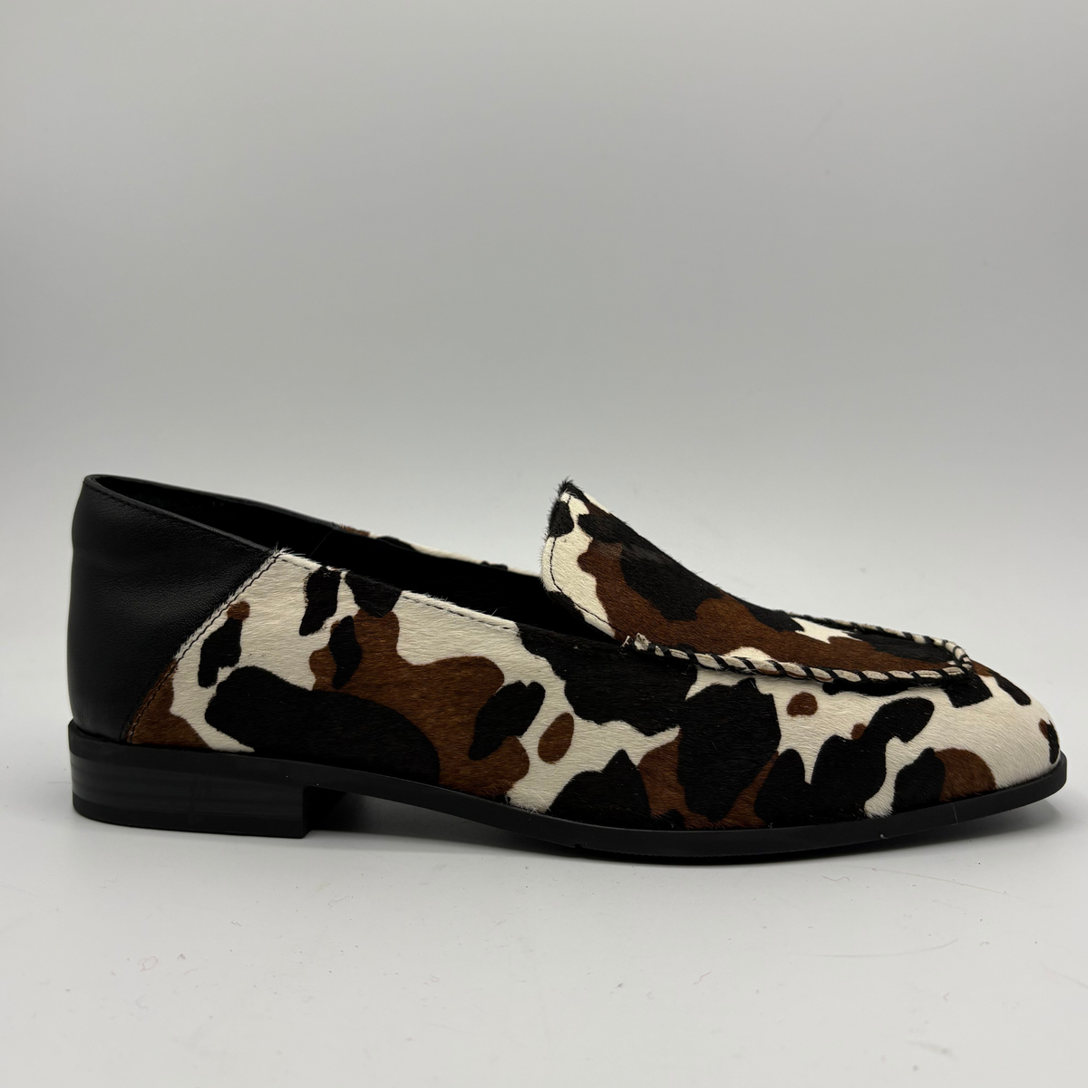 Right facing view of a cow print suede loafer with a low heel