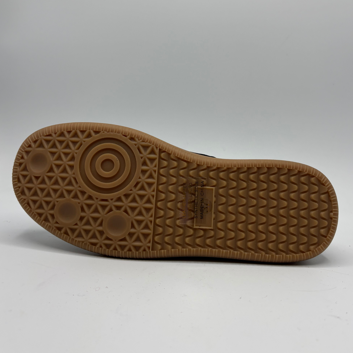 Bottom view of a plaid sneaker with a gum outsole