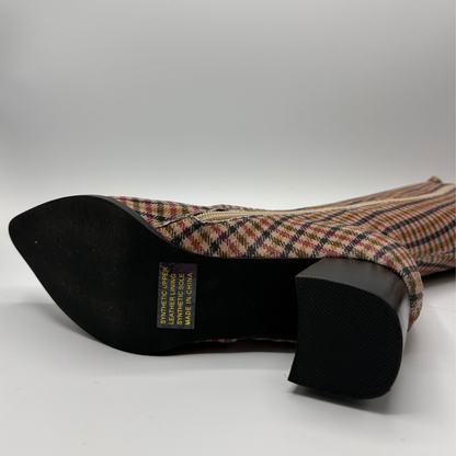 A knee-high pointed-toe boot with a black block heel, featuring a red, black, and white plaid pattern on a clean white background.