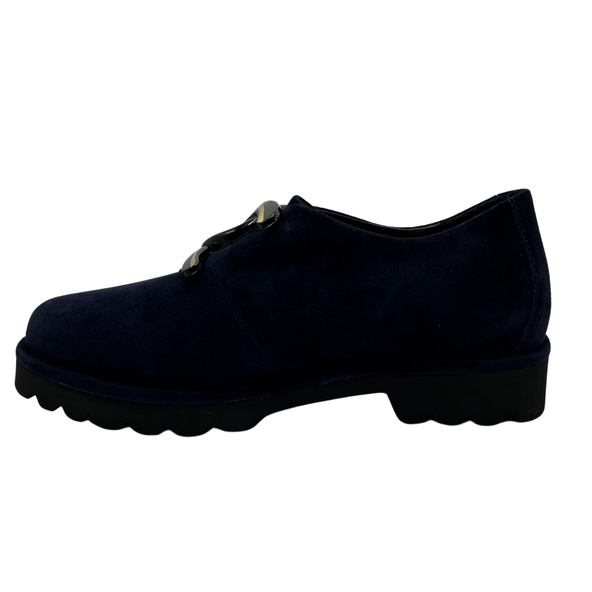 Left facing view of navy suede loafer with thick rubber outsole and gold/black detail on upper