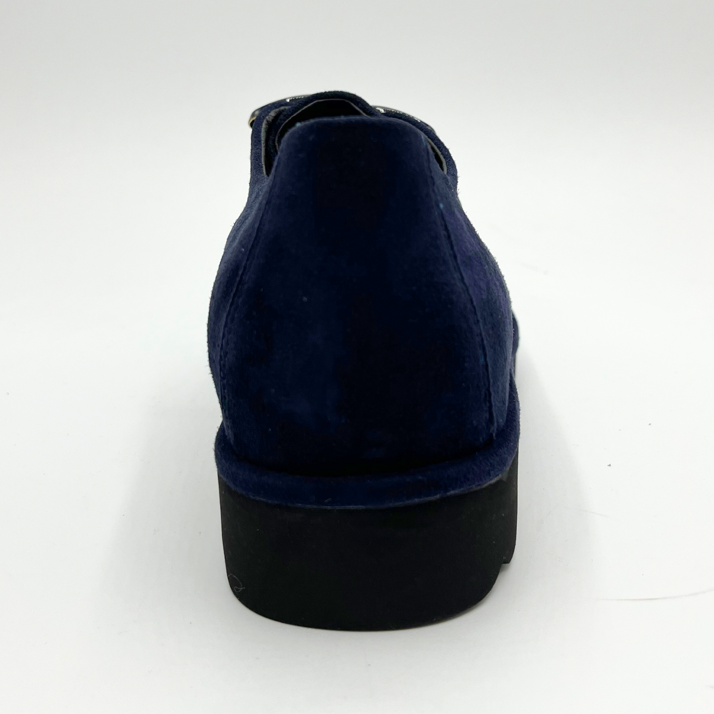 Back view of navy suede loafer with thick rubber outsole and gold/black detail on upper