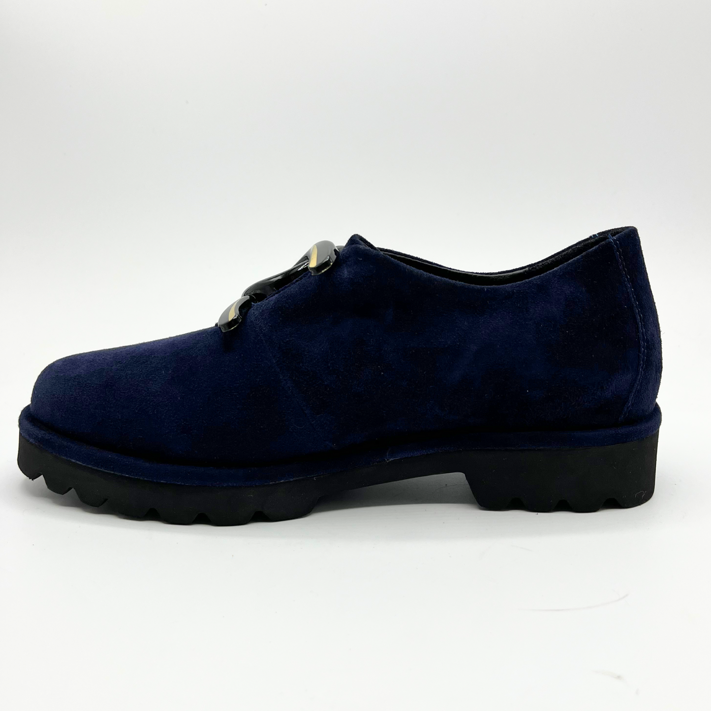 Left facing view of navy suede loafer with thick rubber outsole and gold/black detail on upper