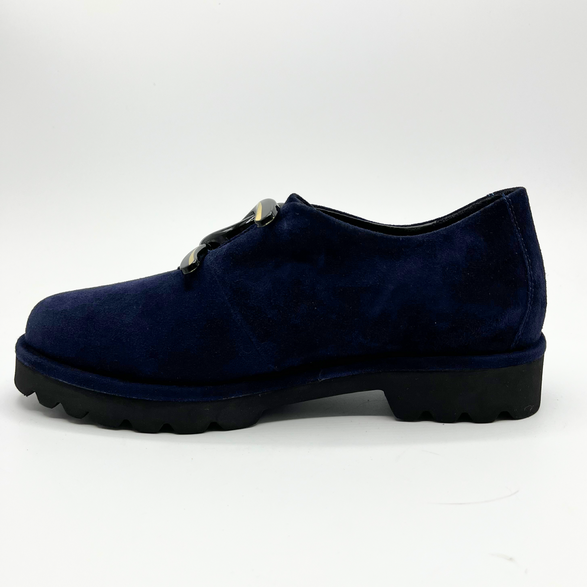 Left facing view of navy suede loafer with thick rubber outsole and gold/black detail on upper