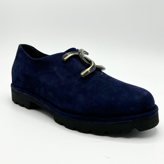 45 degree angled view of navy suede loafer with thick rubber outsole and gold/black detail on upper