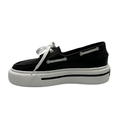 Left facing view of a black leather boat shoe with white rubber platform outsole and white laces