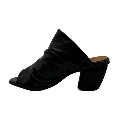 Left facing view of slouchy leather sandal in black. With a muled heel and open toe.