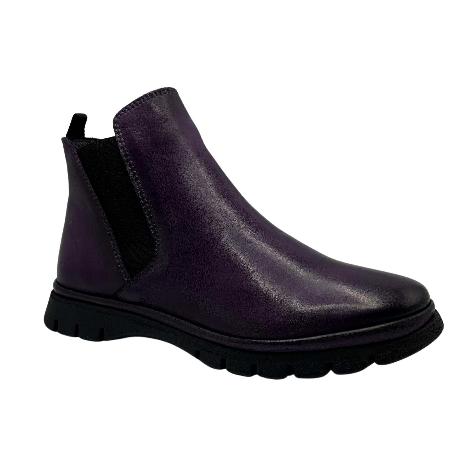 45 degree angled view of dark purple leather short boot with slim black outsole and pull on heel tab. Elastic side gore with rounded toe