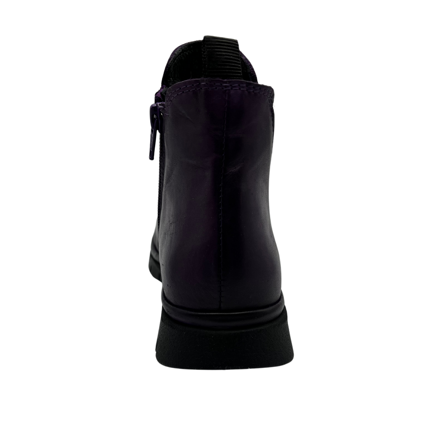 Back view of dark purple leather short boot with slim black outsole and pull on heel tab. Elastic side gore with rounded toe