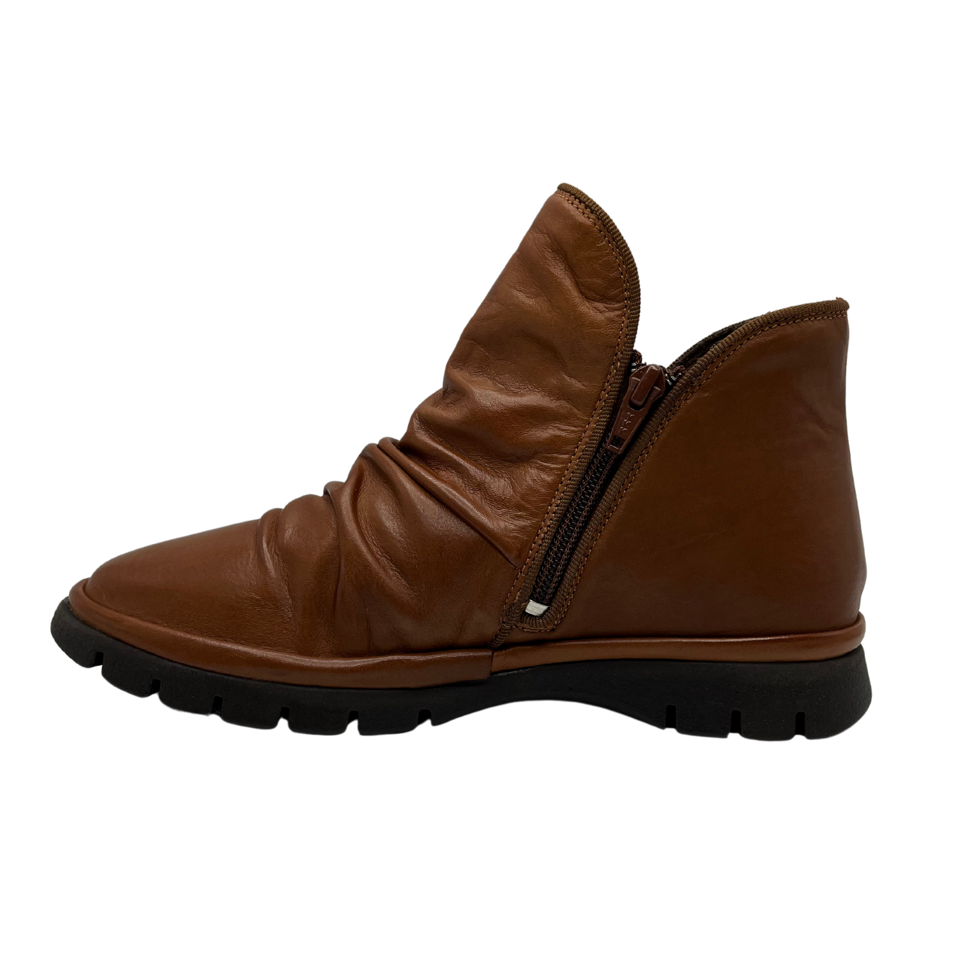 Left facing view of brown leather ankle boot with slouchy upper, double side zipper closures and slim rubber outsole